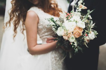 Beauty wedding bouquet with different flowers in hands